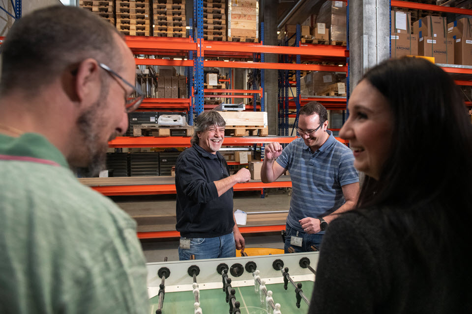 Mitarbeitende spielen Tischfussball und leben die Werte von IWB