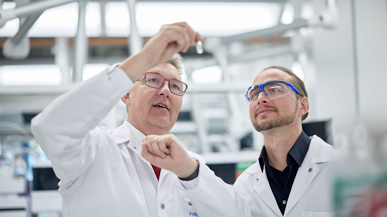 Zwei Männer im Labor betrachten ein Reagenzglas.