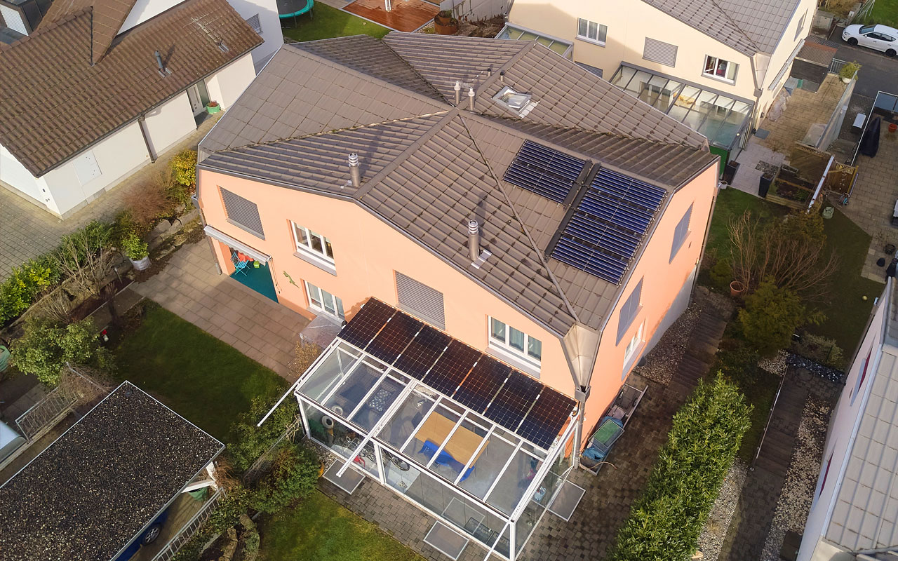 Verschiedene Ansichten eines Hauses, das auf dem Dach eine solarthermische Anlage hat und auf dem Wintergarten eine Photovoltaikanlage.