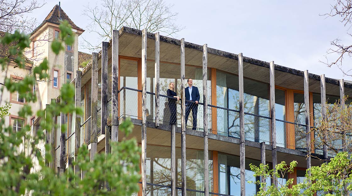 Laura Walter und Alaing Gehrig stehen auf dem Balkon der Schweizer Jugendherberge in Basel
