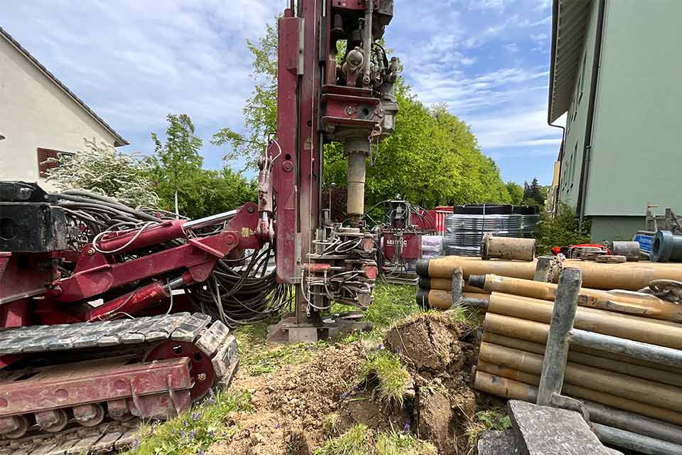 Auf der Baustelle wir ein Loch für die Wärmepumpe gebohrt.